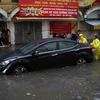 Hỗ trợ đẩy ôtô của người dân ra khỏi vùng ngập trên phố Mạc Thị Bưởi. (Ảnh: Thanh Tùng/TTXVN)