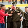 Hỗ trợ binh sĩ Venezuela bị thương tại hiện trường vụ nổ nhằm vào Lễ kỷ niệm 81 năm ngày thành lập Lực lượng Phòng vệ quốc gia ở Caracas ngày 4/8. (Ảnh: THX/TTXVN)