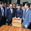 Thủ tướng Nguyễn Xuân Phúc và các đại biểu tham quan các sản phẩm đồ gỗ trưng bày tại hội nghị. (Ảnh: Thống Nhất/TTXVN)