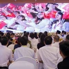 Các đại biểu thanh niên Việt Nam-Trung Quốc xem phóng sự tại Lễ khai mạc. (Ảnh: Văn Điệp/TTXVN)