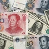 Đồng Nhân dân tệ (phía trên) của Trung Quốc và đồng USD. (Ảnh: Kyodo/TTXVN)