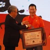 Ông Trương Gia Bình, Chủ tịch Hội đồng quản trị, Tổng Giám đốc Tập đoàn FPT nhận bằng chứng nhận kỷ lục Việt Nam. (Ảnh: Thế Anh/TTXVN)