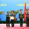 Thượng tướng Chansamone Chanyalath trao Huân chương Tự do Itxala của Nhà nước Lào cho Thượng tướng Phan Văn Giang. (Ảnh: Dương Giang/TTXVN)