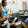 Giao dịch tiền tệ tại ngân hàng thương mại BanPanal ở Caracas, Venezuela. (Ảnh: AFP/ TTXVN)