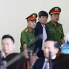 Bị cáo Nguyễn Thanh Hóa, nguyên Cục trưởng Cục Cảnh sát Phòng chống tội phạm sử dụng công nghệ cao được dẫn giải vào phòng chờ xét xử. (Ảnh: Trung Kiên/TTXVN)