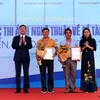 Đồng chí Bùi Trường Giang, Phó trưởng Ban Tuyên giáo Trung ương và Thứ trưởng Bộ Văn hóa, Thể thao và Du lịch Trịnh Thị Thủy trao Giải nhất cho các tác giả. (Ảnh: Danh Lam/TTXVN)