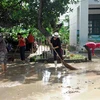 Giáo viên các trường tại Khánh Hòa tích cực dọn dẹp bùn đất để đón học sinh trở lại. (Ảnh: Phan Sáu/TTXVN)
