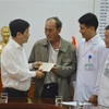 Thứ trưởng Bộ Công an Nguyễn Văn Sơn (trái) tặng quà cho gia đình nạn nhân Ngô Thị Su Sal. (Ảnh: Đinh Văn Nhiều/TTXVN)