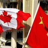 Quốc kỳ Canada (trái) và Quốc kỳ Trung Quốc tại Bắc Kinh. (Ảnh: South China Morning Post/TTXVN)