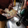 Người dân dùng đồng Bolivar để thanh toán tiền xăng tại Caracas, Venezuela, ngày 14/8/2018. (Ảnh: AFP/ TTXVN)
