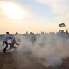 Người biểu tình Palestine chạy trốn đạn hơi cay trong cuộc xung đột với binh sỹ Israel tại thành phố biên giới Khan Yunis, phía nam Dải Gaza ngày 9/11/2018. (Ảnh: AFP/ TTXVN)