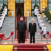 Tổng Bí thư, Chủ tịch nước Nguyễn Phú Trọng và Chủ tịch Triều Tiên Kim Jong-un trên bục danh dự, thực hiện nghi lễ chào cờ. (Ảnh: Trí Dũng/TTXVN)