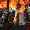 Nhân viên cứu hỏa nỗ lực dập các đám cháy do người biểu tình "Áo vàng" đốt tại đại lộ Champs Elysees ở Paris. (Ảnh: AFP/TTXVN)