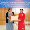 Chủ tịch Liên hiệp các tổ chức hữu nghị Việt Nam Nguyễn Phương Nga trao tặng Huân chương Hữu nghị của Chủ tịch nước cho bà Susan Hammond - Người sáng lập của tổ chức WLP - Dự án Giải quyết Di sản chiến tranh (Mỹ). (Ảnh: Văn Điệp/TTXVN)