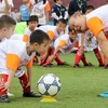 HLV Park Hang Seo hướng dẫn các em học sinh khởi động trước khi chơi bóng đá. (Ảnh: Trung Kiên/TTXVN)