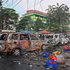 Người biểu tình đập phá, đốt xe ôtô tại Jakarta ngày 22/5. (Ảnh: AFP/TTXVN)