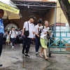 Mưa lớn khiến thí sinh gặp khó khăn khi rời khỏi điểm thi tại Hội đồng thi Trường THPT Marie Curie, Quận 3, Thành phố Hồ Chí Minh. (Ảnh: Xuân Dự/TTXVN)