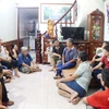 Thuyền viên Đinh Trọng Dũng, 57 tuổi (áo xanh ngồi trên giường) chia sẻ với gia đình và người thân. (Ảnh: Nguyễn Oanh/TTXVN)