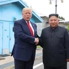 Tổng thống Mỹ Donald Trump (trái) và nhà lãnh đạo Triều Tiên Kim Jong-un trong cuộc gặp ở làng đình chiến Panmunjom tại Khu phi quân sự (DMZ) chiều 30/6/2019. (Ảnh: AFP/TTXVN)