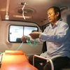 Ông Ngô Văn Đậu đang kiểm tra lại các thiết bị hỗ trợ cấp cứu trên xe chuyển viện do ông và gia đình mua trị giá 700 triệu đồng để vận chuyển bệnh nhân miễn phí. (Ảnh: Công Mạo/TTXVN)