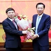 Cựu Bí thư Tỉnh ủy Quảng Ninh Nguyễn Văn Đọc (bên phải) tặng hoa chúc mừng ông Nguyễn Xuân Ký được bầu làm Bí thư Tỉnh ủy. (Ảnh: Văn Đức/TTXVN)