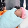 Bé sơ sinh bị bỏ rơi trước cổng chùa đang được chăm sóc tại trạm y tế xã Nghĩa Trung. (Ảnh: Đậu Tất Thành/Vietnam+) 