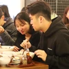Các bạn trẻ du học sinh Việt Nam tại Melbourne thích thú thưởng thức Phở Thìn 13 Lò Đúc. (Ảnh: Diệu Linh/Vietnam+)