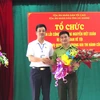 Phó Chánh án TAND tỉnh Hà Giang Trương Huy Huân tặng hoa cho ông Nguyễn Viết Xuân. (Ảnh: Minh Tâm-TTXVN)