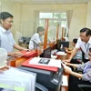 Khách hàng đến giao dịch tại Cục Thuế tỉnh Quảng Bình. (Ảnh: Phạm Hậu/TTXVN)