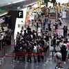 Hành khách tại sân bay Haneda ở thủ đô Tokyo, Nhật Bản. (Ảnh: AFP/ TTXVN)