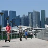 Khách du lịch lái e-scooter tại Singapore ngày 19/2/2019. (Ảnh: AFP/TTXVN)