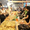 Đông đảo thực khách trong nước và quốc tế thưởng thức món bánh khọt tại liên hoan. (Ảnh: Thanh Vũ/TTXVN)