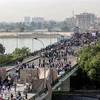 Người biểu tình phản đối chính phủ Iraq tràn vào cây cầu al-Sinek để tiến vào vùng Xanh ở thủ đô Baghdad ngày 17/11/2019. (Ảnh: AFP/TTXVN)