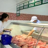 Khách hàng chọn mua thịt lợn tại siêu thị Co.opmart Hà Đông (Hà Nội). (Ảnh: TTXVN)