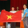 Câu lạc bộ Tuổi trẻ vì biển đảo quê hương chuyển lá cờ Tổ quốc có chữ ký của đội tuyển bóng đá U22 Việt Nam đến các chiến sỹ đang làm nhiệm vụ trên quần đảo Trường Sa và Nhà giàn DK1. (Ảnh: Nguyễn Văn Nhật/TTXVN)