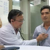 Tiến sỹ, bác sỹ Nguyễn Thái An, Trưởng Khoa Hồi sức phẫu thuật tim - Bệnh viện Chợ Rẫy tái khám cho bệnh nhân sau khi áp dung phương pháp phẫu thuật tim mới. (Ảnh: Đinh Hằng/TTXVN)