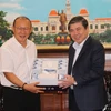 Chủ tịch UBND Thành phố Hồ Chí Minh Nguyễn Thành Phong tặng quà lưu niệm cho Huấn luyện viên Park Hang-seo. (Ảnh: Hứa Chung/TTXVN)