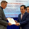 Ông Dương Thành Trung, Chủ tịch UBND tỉnh Bạc Liêu trao quyết định chủ trương đầu tư cho đại diện Công ty TNHH Delta Offshore Energy Pte. Ltd. (Ảnh: Huỳnh Sử/TTXVN)