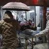 Nhân viên y tế chuyển bệnh nhân nhiễm virus corona mới gây bệnh viêm phổi tới bệnh viện ở Vũ Hán, tỉnh Hồ Bắc, Trung Quốc ngày 25/1/2020. (Ảnh: AFP/TTXVN)