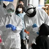 Nhân viên y tế Hàn Quốc lấy mẫu bệnh phẩm của các nhân viên bị nghi nhiễm COVID-19 tại một tòa nhà ở Seoul, nơi phát hiện 46 ca dương tính với virus SARS-CoV-2, ngày 10/3/2020. (Ảnh: AFP/TTXVN)
