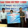 Đại diện gia đình ông Chu Bảo Quế trao tặng vật tư y tế cho UBND huyện Việt Yên, Bắc Giang. (Ảnh: Đồng Thúy/TTXVN)