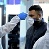 Nhân viên y tế kiểm tra thân nhiệt của người dân trong bối cảnh dịch COVID-19 lan rộng tại Tehran, Iran. (Ảnh: IRNA/ TTXVN)