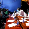 Sinh viên tình nguyện hướng dẫn người dân khai báo y tế tại chốt kiểm soát y tế thị xã Hương Trà. (Ảnh: Tường Vi/TTXVN)