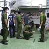 Lực lượng chức năng thu thập thông tin tại hiện trường vụ án. (Ảnh: Nguyễn Văn Việt/TTXVN)