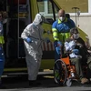 Nhân viên y tế chuyển bệnh nhân nhiễm COVID-19 tới bệnh viện ở Madrid, Tây Ban Nha ngày 2/4/2020. (Ảnh: AFP/TTXVN)