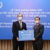 Thứ trưởng Bộ Ngoại giao Lê Hoài Trung trao tượng trưng số tiền 50.000 USD của Chính phủ và nhân dân Việt Nam đến Trưởng Đại diện Tổ chức Y tế Thế giới tại Việt Nam Kidong Park. (Ảnh: Lâm Khánh/TTXVN)