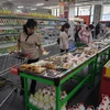 Người dân Triều Tiên mua sắm thực phẩm sản xuất trong nước tại một siêu thị ở Bình Nhưỡng. (Ảnh: AFP/TTXVN)