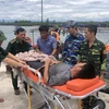 Lực lượng Bộ đội Biên phòng Quảng Trị đưa thuyền viên bị bệnh vào bờ để điều trị. (Ảnh: TTXVN phát)
