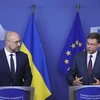 Thủ tướng Ukraine Denys Shmyhal (trái) và Ủy viên châu Âu phụ trách kinh tế Valdis Dombrovskis sau khi ký thỏa thuận hỗ trợ tài chính vĩ mô ở Brussels, Bỉ ngày 23/7/2020. (Ảnh: AFP/TTXVN)