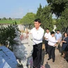 Đoàn đại biểu Thông tấn xã Việt Nam do Tổng Giám đốc Nguyễn Đức Lợi dẫn đầu đến đặt vòng hoa và dâng hương viếng các liệt sỹ tại nghĩa trang liệt sỹ thị trấn Chúc Sơn. (Ảnh: Dương Giang/TTXVN)